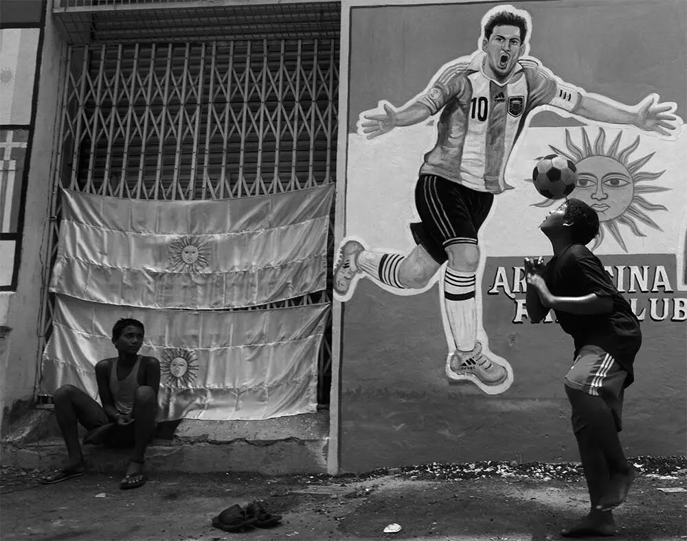 Мальчик отбивает мяч головой напротив граффити с изображением Лионеля Месси в - фото 1
