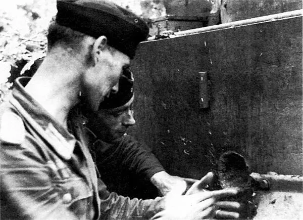 Немецкие танкисты рассматривают след попадания вражеского снаряда в борту - фото 117