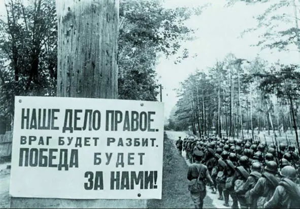 Колонна шагает по просёлочной дороге мимо столба с немудреной фанеркой на - фото 2
