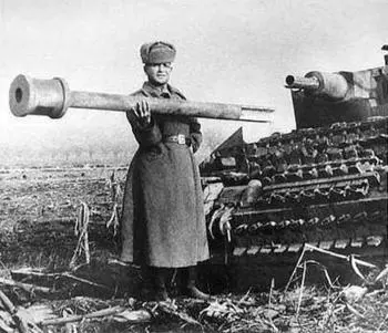Советский солдат держит в руках обломок имитационного орудия немецкого - фото 1