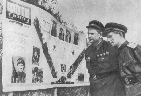 Писатель В П Ставский слева у фотогазеты посвященной лучшим снайперам - фото 49