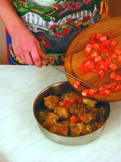 Нарезанные кубиками помидоры добавить к содержимому сковороды Плов с курицей - фото 174