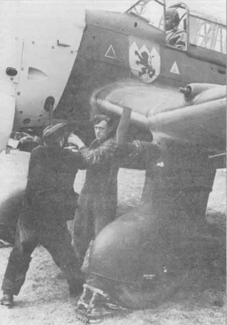 Механики с помощью ручки дружбы запускают двигатель бомбардировщика Ju87B - фото 98
