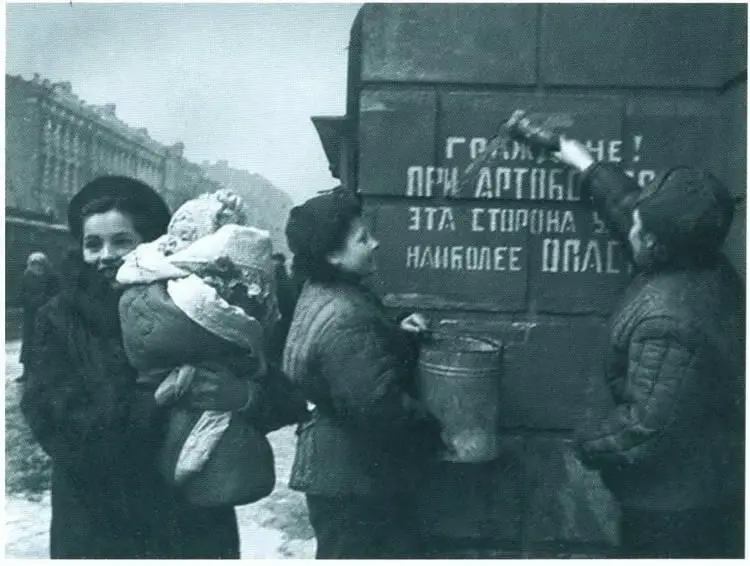 Ленинградцы закрашивают на стене дома надпись предупреждающую об артобстрелах - фото 67
