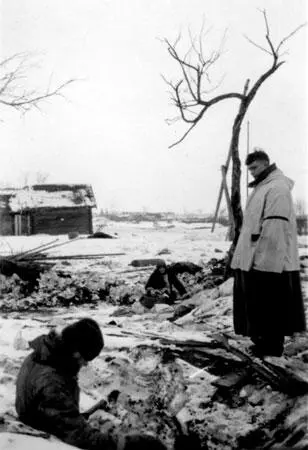 Немецкий солдат осматривает трупы местных жителей одной из уничтоженных - фото 436