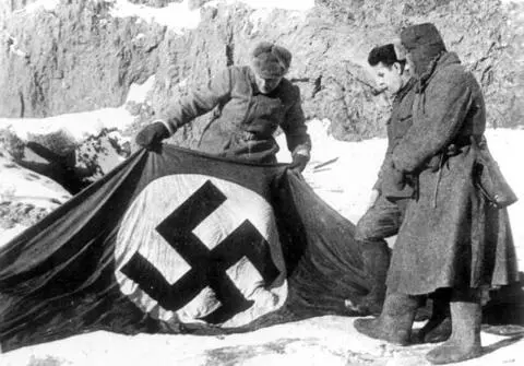 Советские бойцы рассматривают захваченный нацистский флаг на берегу Волги в - фото 92