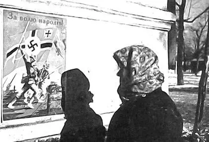 Жительница Харькова проходит мимо пропагандистского фашистского плаката - фото 192