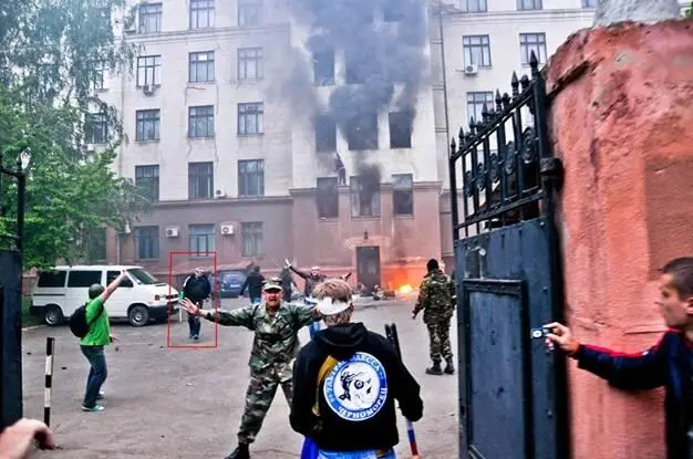 Человек в камуфляжной форме пытается остановить озверевших майдановцев - фото 41