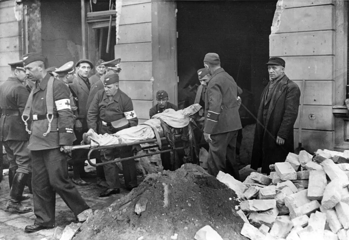 Рис 31 Рабочие выносят из здания жертву бомбового удара Берлин 1944 г На - фото 11